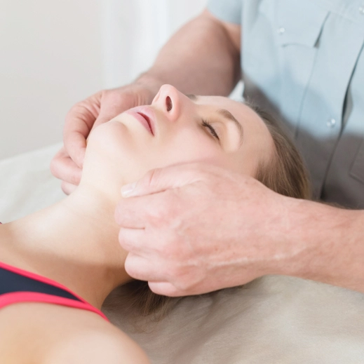 Physiotherapist treating a woman’s jaw
